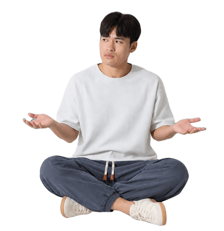 A man sitting cross-legged, shrugging
